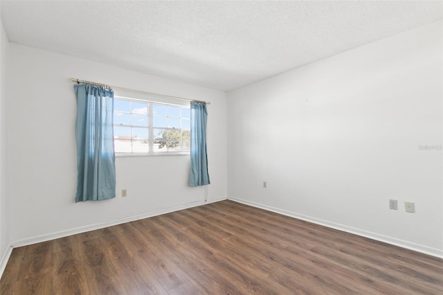 empty room featuring dark hardwood / wood-style flooring and a textured ceiling