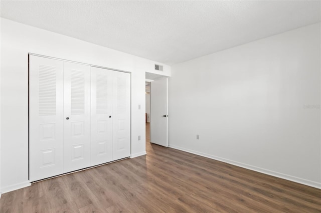 unfurnished bedroom with hardwood / wood-style floors and a closet