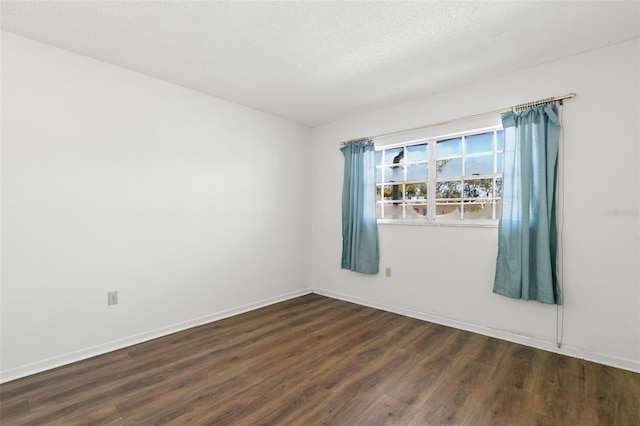 spare room with dark hardwood / wood-style flooring and a textured ceiling