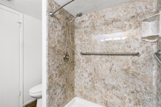 bathroom featuring a tile shower, a textured ceiling, and toilet