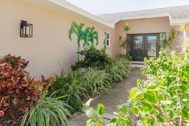 view of exterior entry with stucco siding and french doors