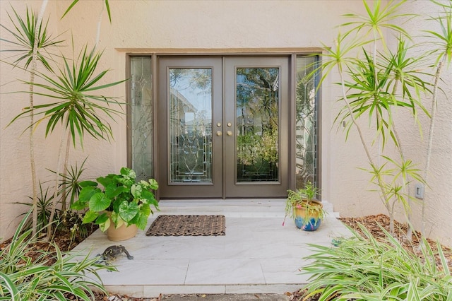 view of exterior entry with french doors and stucco siding