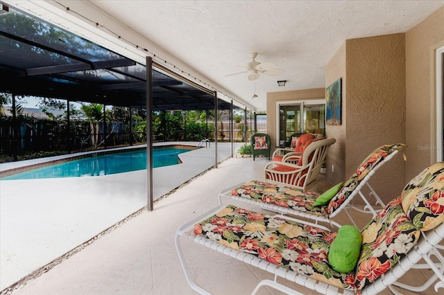 view of swimming pool with a fenced in pool, a patio, glass enclosure, a fenced backyard, and ceiling fan