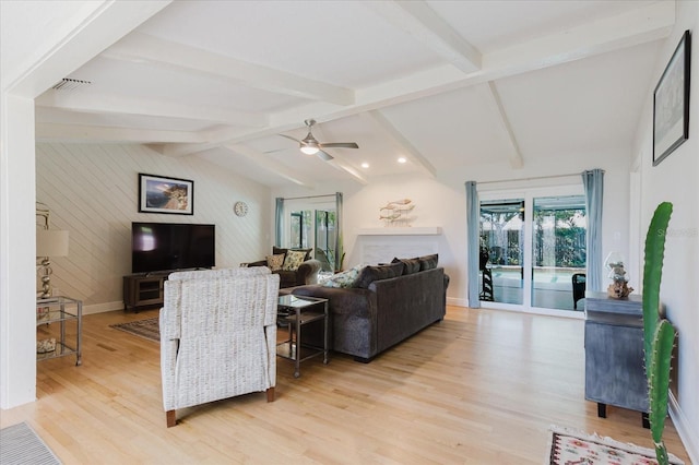 living room with a wealth of natural light, baseboards, lofted ceiling with beams, and light wood finished floors