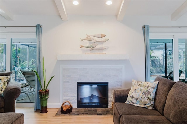 living room with a fireplace with flush hearth, recessed lighting, beamed ceiling, and wood finished floors