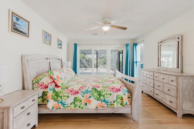 bedroom featuring light wood-type flooring, access to exterior, a textured ceiling, and a ceiling fan