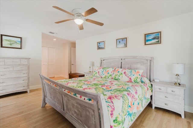 bedroom with a closet, light wood-type flooring, visible vents, and baseboards