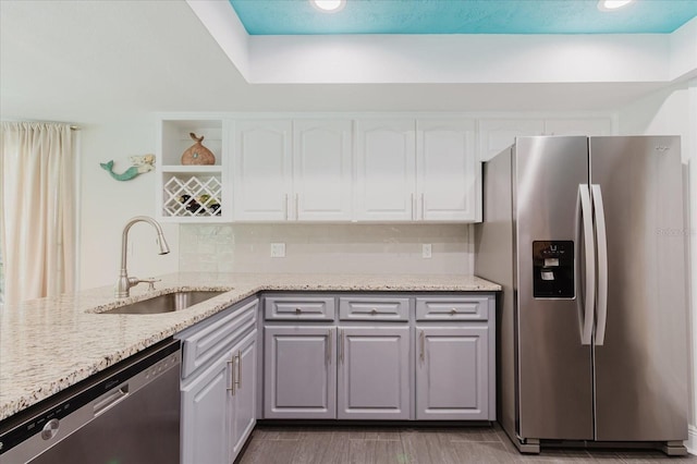 kitchen with tasteful backsplash, stainless steel appliances, white cabinetry, open shelves, and a sink