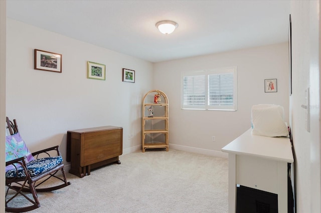 living area featuring baseboards and light colored carpet