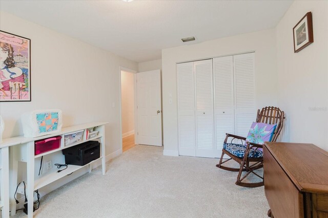 sitting room with carpet flooring, visible vents, and baseboards