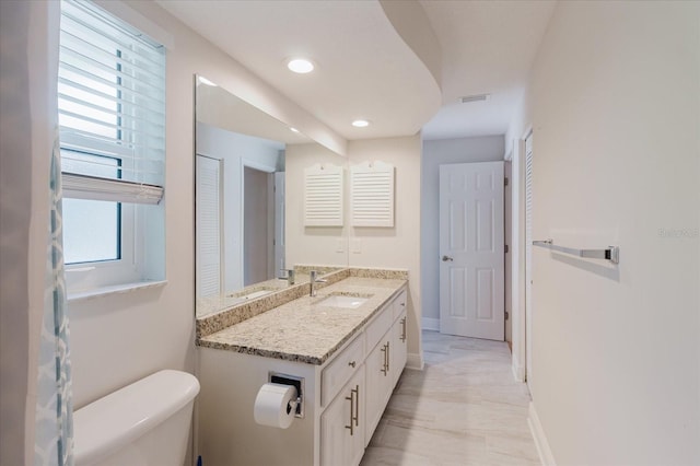 bathroom with toilet, recessed lighting, visible vents, vanity, and baseboards