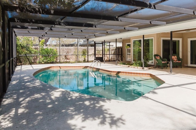 view of swimming pool featuring glass enclosure, a fenced in pool, and a patio