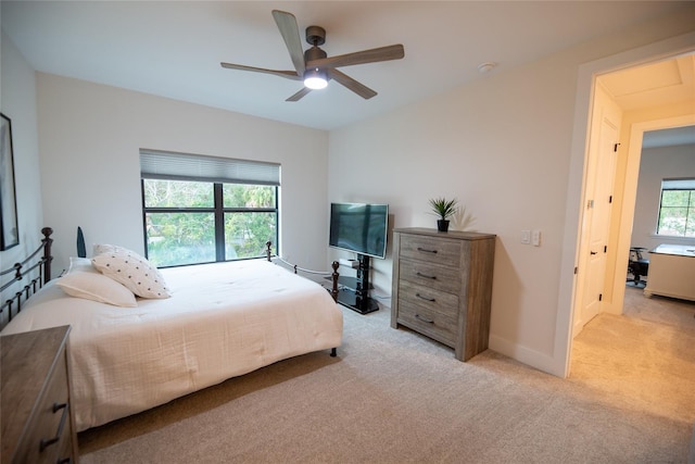 bedroom with baseboards, a ceiling fan, and light colored carpet