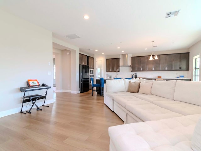 living room with sink and light hardwood / wood-style flooring