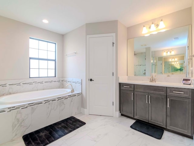 bathroom featuring vanity and tiled tub