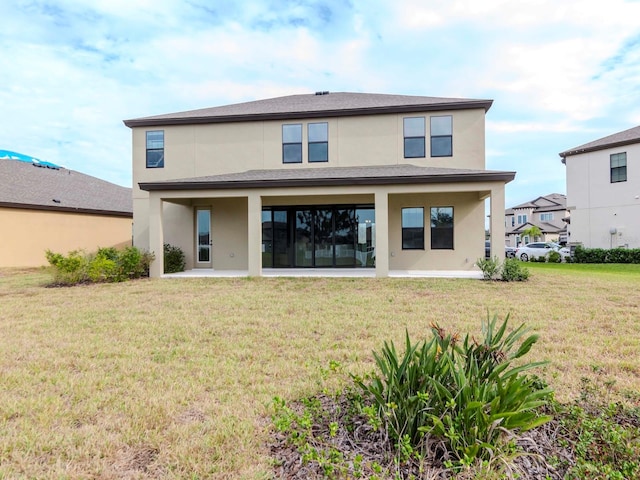 back of property with a patio area and a lawn