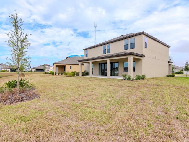 rear view of house featuring a yard