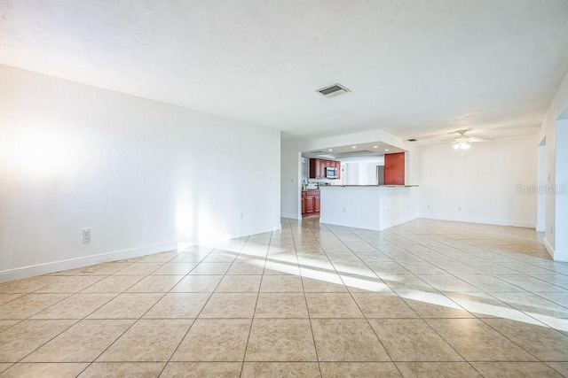 unfurnished living room featuring ceiling fan and light tile patterned floors