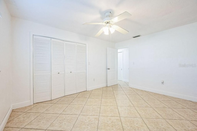 unfurnished bedroom with ceiling fan, light tile patterned floors, and a closet