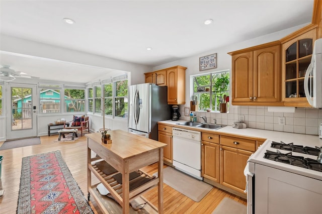 kitchen with a wealth of natural light, white appliances, ceiling fan, and sink