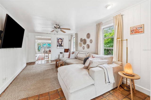 living room with tile patterned floors, ceiling fan, and crown molding