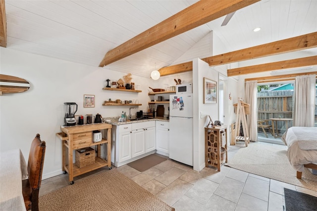 kitchen featuring white cabinets, vaulted ceiling with beams, white refrigerator, and light tile patterned floors