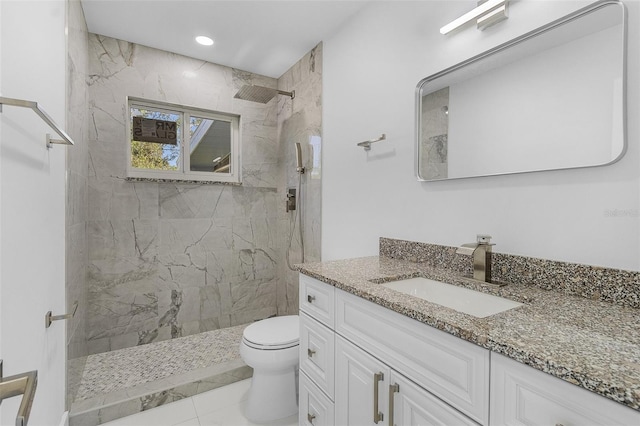 bathroom featuring tiled shower, tile patterned floors, vanity, and toilet