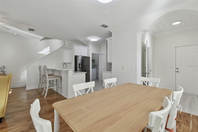 dining space featuring dark hardwood / wood-style floors, washer / clothes dryer, ornamental molding, and ceiling fan