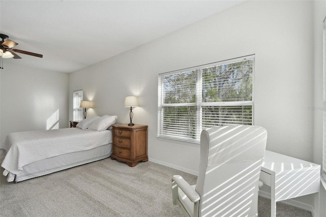 bedroom with multiple windows, light carpet, and ceiling fan