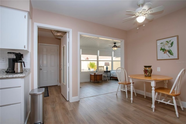 dining area featuring ceiling fan, light wood-style flooring, and baseboards