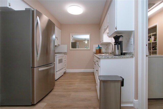 kitchen featuring white appliances, white cabinets, light countertops, light wood-type flooring, and a sink