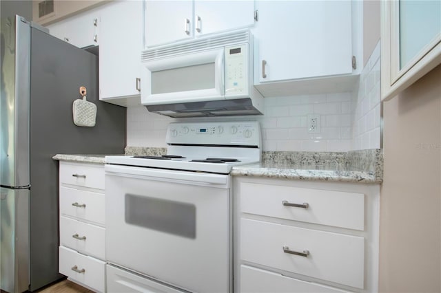 kitchen featuring white appliances, visible vents, white cabinets, light stone counters, and backsplash