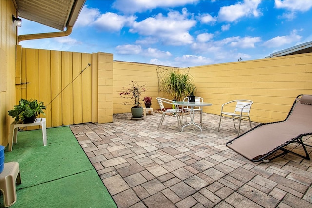 view of patio featuring outdoor dining area and fence