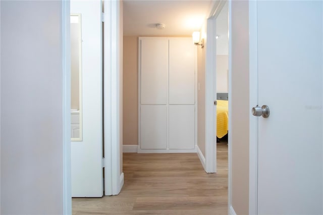 hallway with light wood-style floors and baseboards