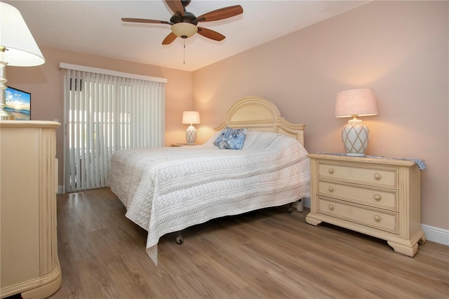 bedroom with ceiling fan, baseboards, and wood finished floors