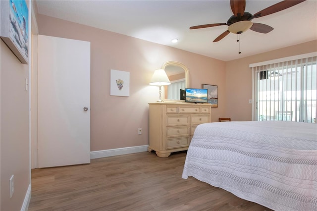 bedroom with light wood finished floors, ceiling fan, and baseboards