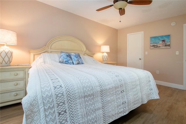 bedroom with ceiling fan, baseboards, and wood finished floors