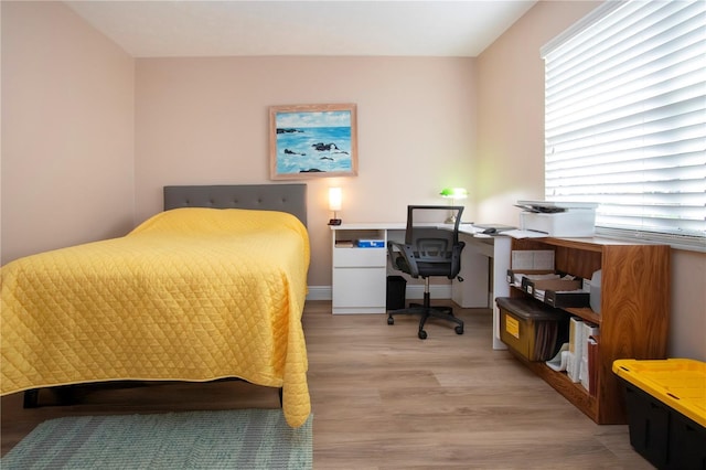 bedroom with light wood-type flooring and baseboards