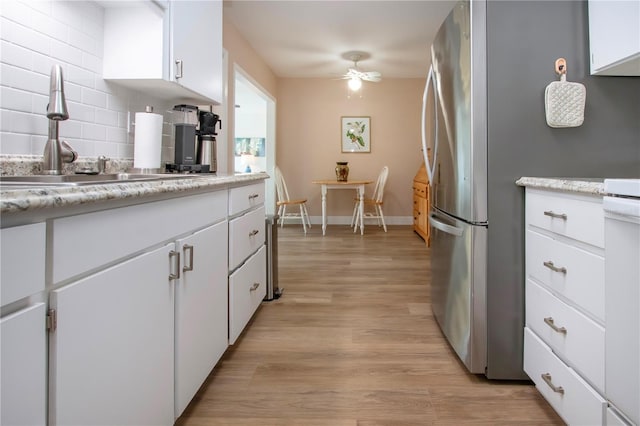 kitchen with ceiling fan, backsplash, light countertops, light wood-type flooring, and a sink