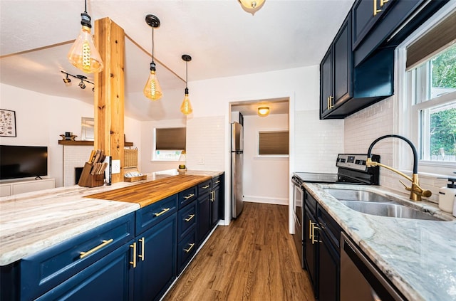 kitchen featuring appliances with stainless steel finishes, dark wood-type flooring, sink, blue cabinetry, and hanging light fixtures