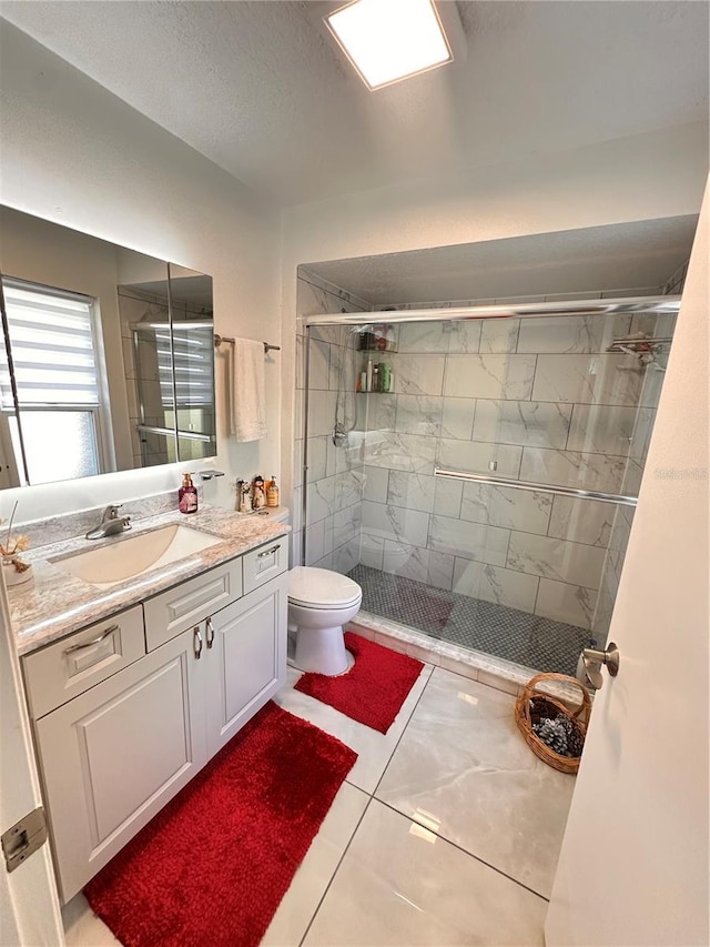 bathroom featuring tile patterned flooring, vanity, toilet, and an enclosed shower