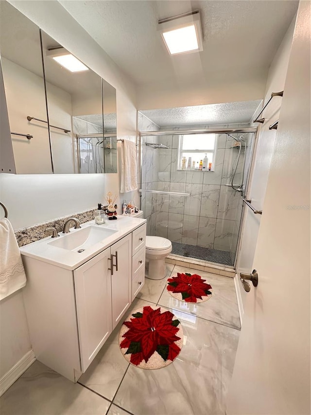 bathroom featuring a textured ceiling, vanity, an enclosed shower, and toilet