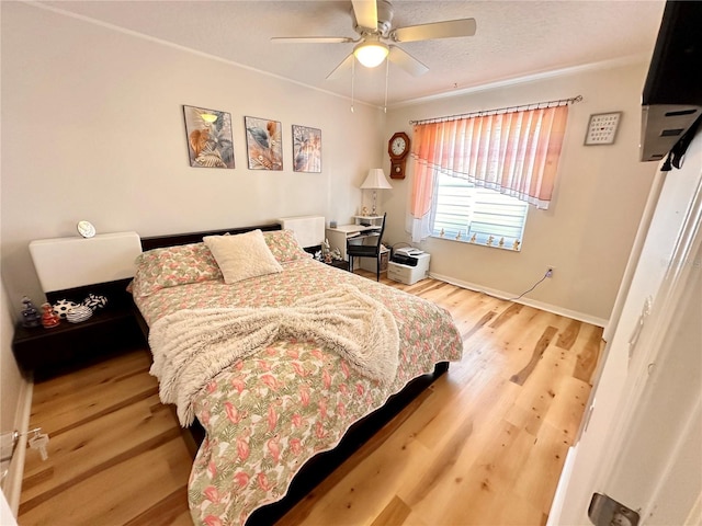 bedroom with ornamental molding, ceiling fan, wood finished floors, and baseboards