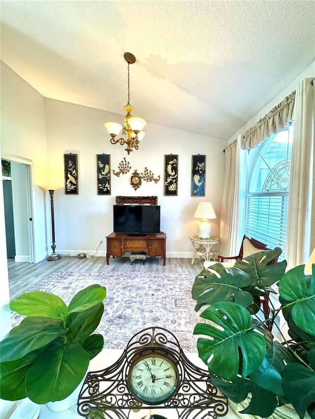 living room with an inviting chandelier, vaulted ceiling, hardwood / wood-style floors, and a textured ceiling