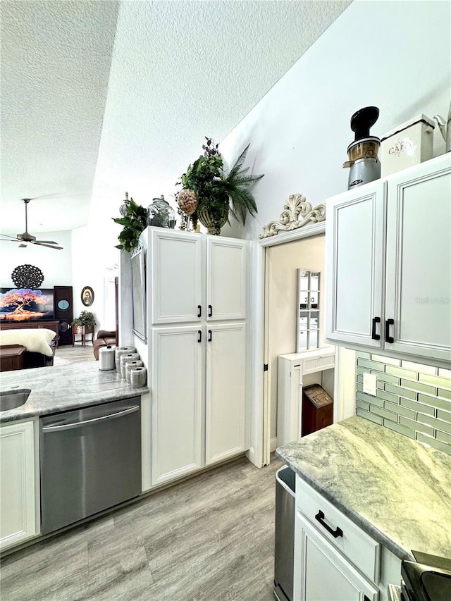 kitchen with ceiling fan, light stone counters, tasteful backsplash, white cabinets, and stainless steel dishwasher