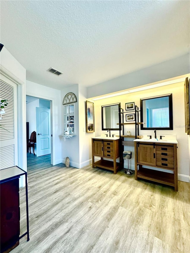 bathroom featuring vanity, wood-type flooring, and a textured ceiling