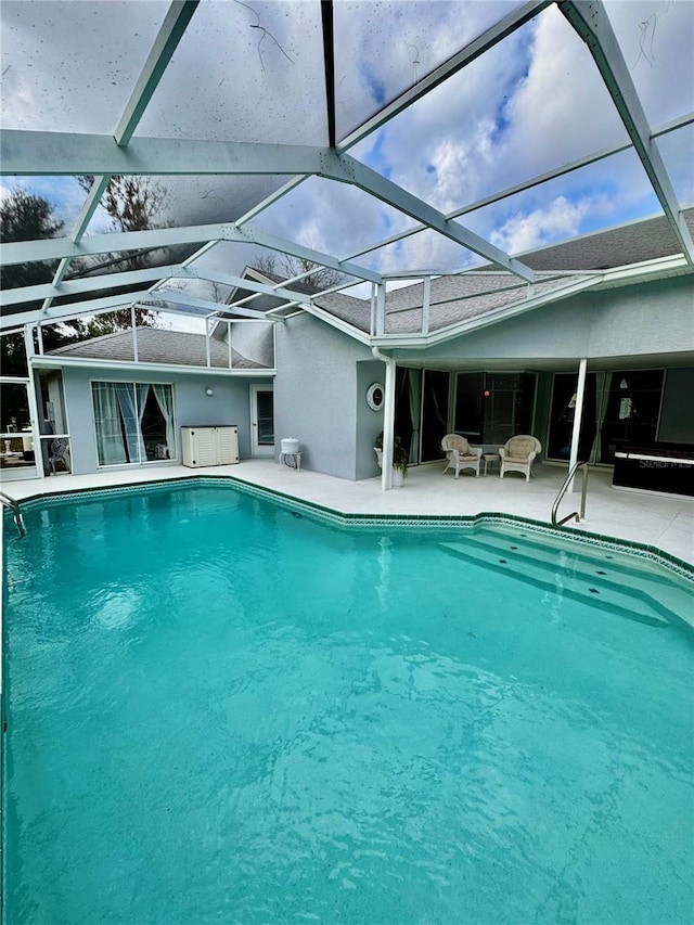 view of swimming pool featuring a lanai and a patio