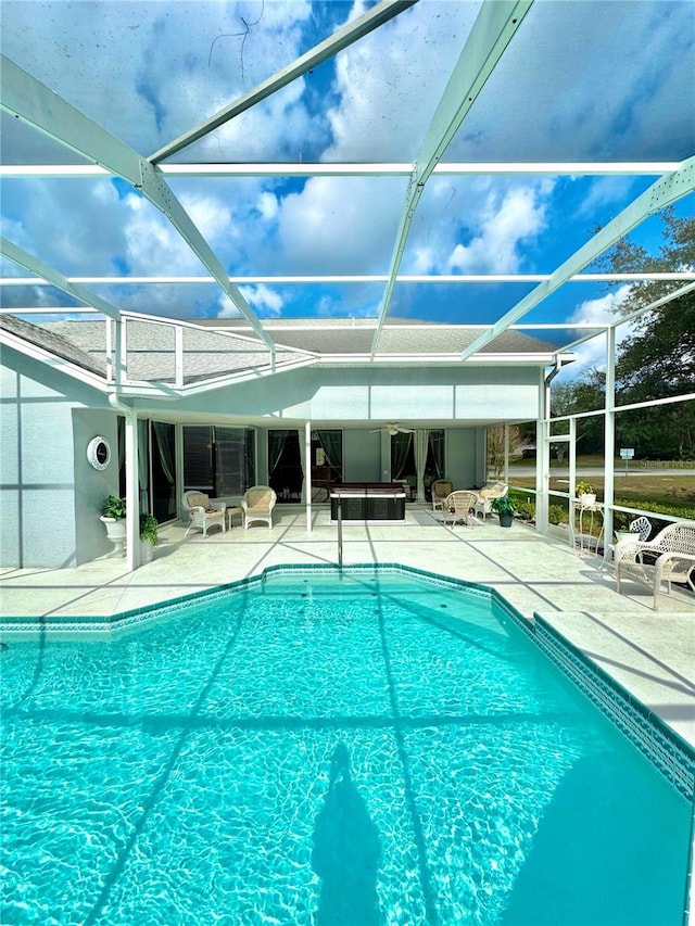 view of pool with a patio and glass enclosure