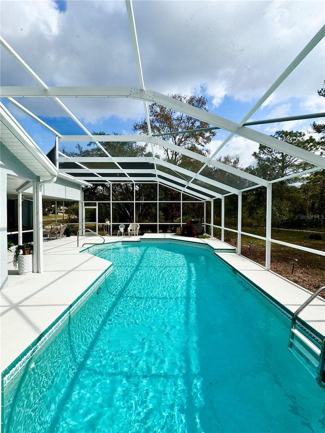 view of swimming pool with a patio and glass enclosure