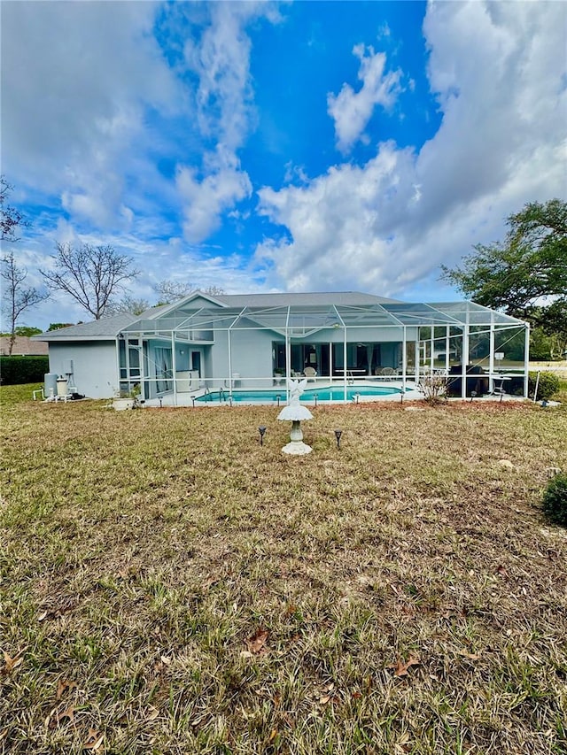 back of house featuring a lanai and a yard